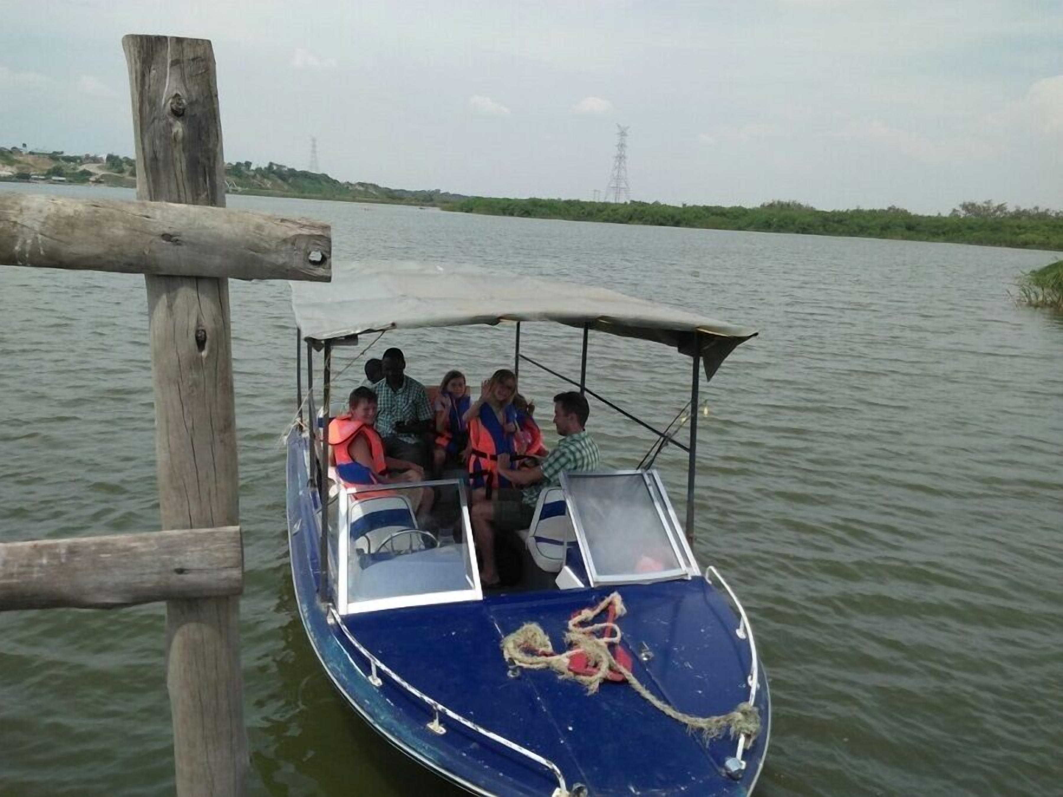 Un bote con pasajeros usando chalecos salvavidas, amarrado a un muelle de madera.