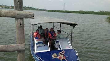 Un bote con pasajeros usando chalecos salvavidas, amarrado a un muelle de madera.