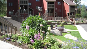 A red brick building with multiple balconies and a wooden deck.
