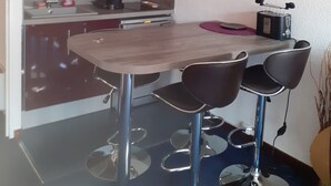 Une cuisine de taille réduite avec un coin repas, comprenant une table et quatre chaises.