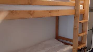 A bunk bed with a wooden frame and white bedding.