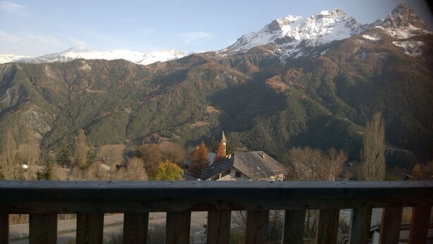 Un paysage de montagne avec une église et des immeubles d’habitation.