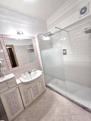 Tina con regadera, secadora de cabello, bidet, toallas 