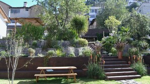 A garden with a wooden bench, stone steps, and various plants. - Romantic Cottage in a beautiful garden in  the Historic  Center of Quito (Quito)