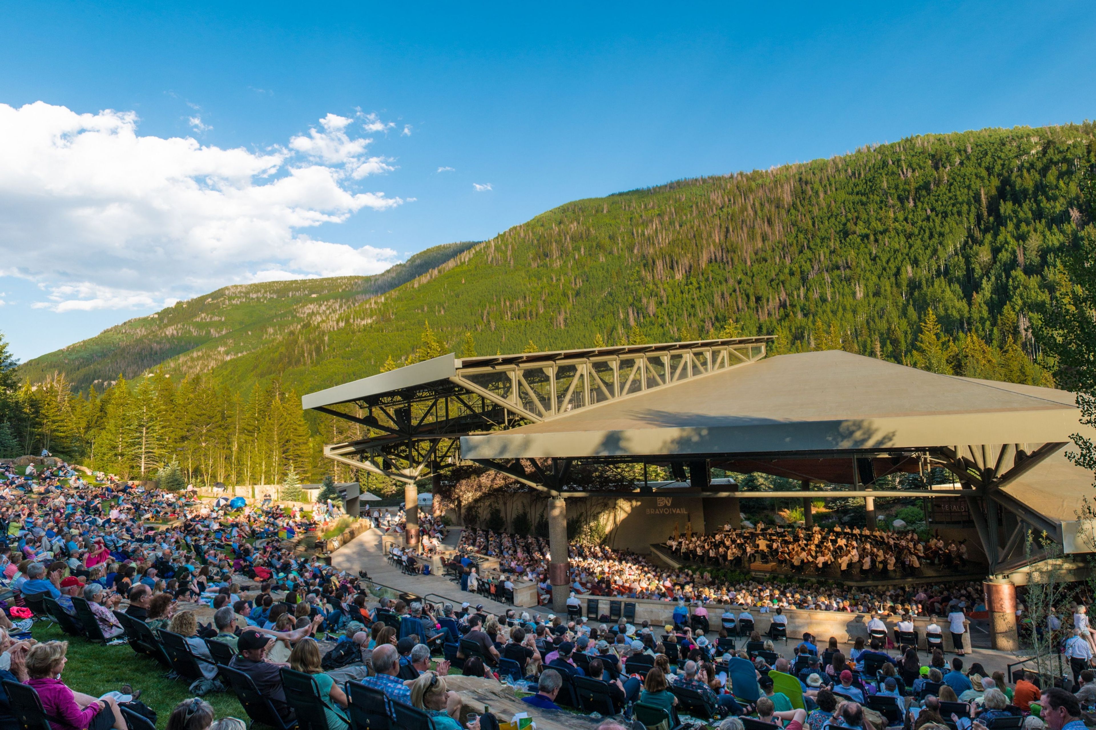 Un amphithéâtre en plein air doté de gradins et d’une scène, le tout entouré d ’un paysage montagneux.