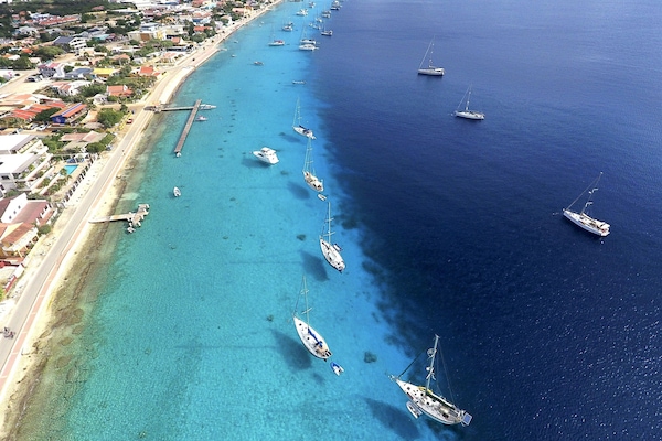 Stroll along downtown Kralendijk's vibrant malecón, where stunning views of sailboats gliding on blue waters and the picturesque Klein Bonaire await.
