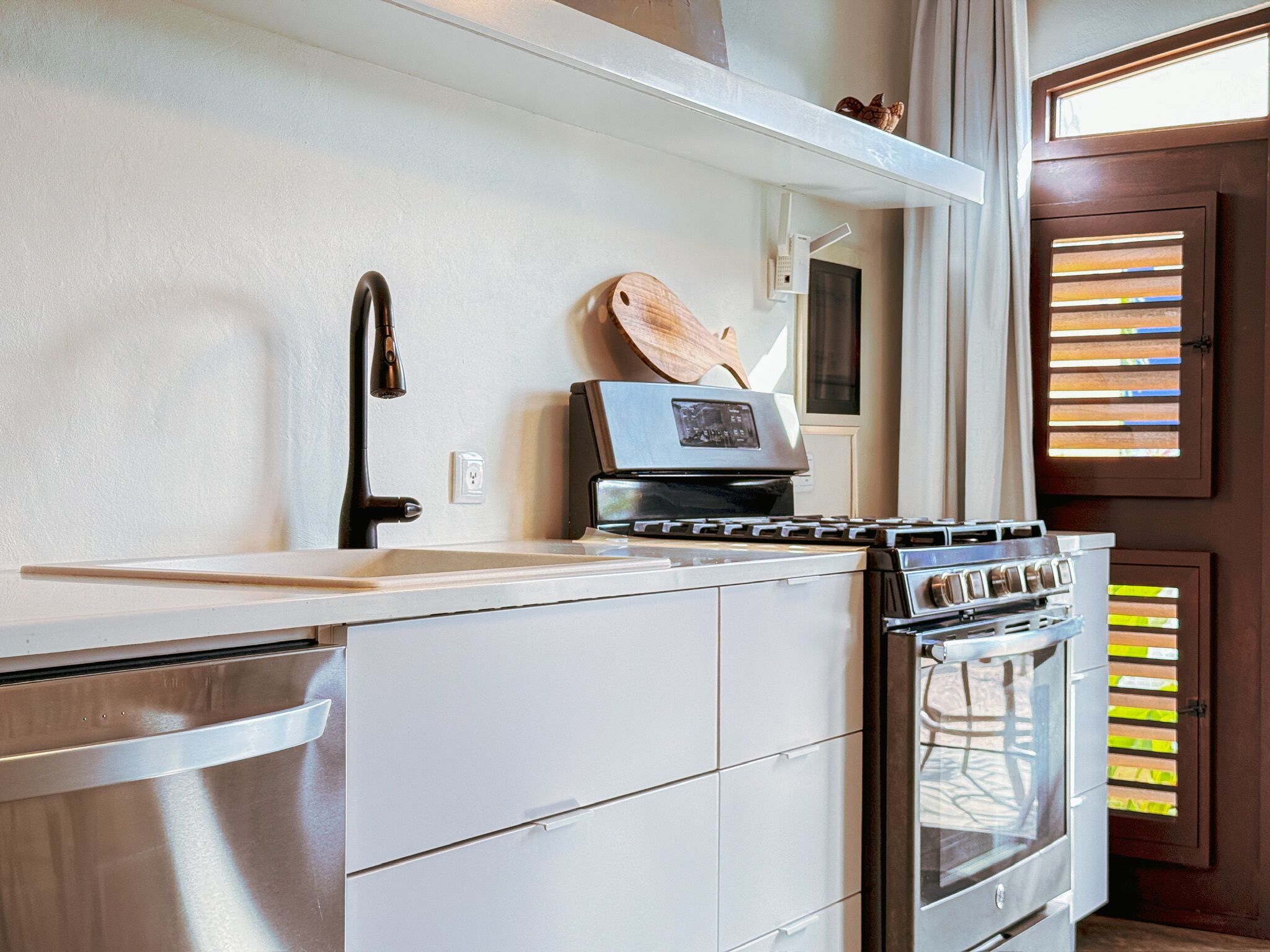 A compact kitchen with a built-in oven, a stovetop, and a sink.