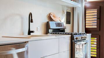 A compact kitchen with a built-in oven, a stovetop, and a sink.