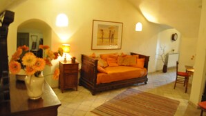 A cozy bedroom with a wooden bed, a nightstand, a lamp, and a vase of flowers. - A Gorgeous Large Flat in Trastevere with a Beautiful Terrace (Roma)