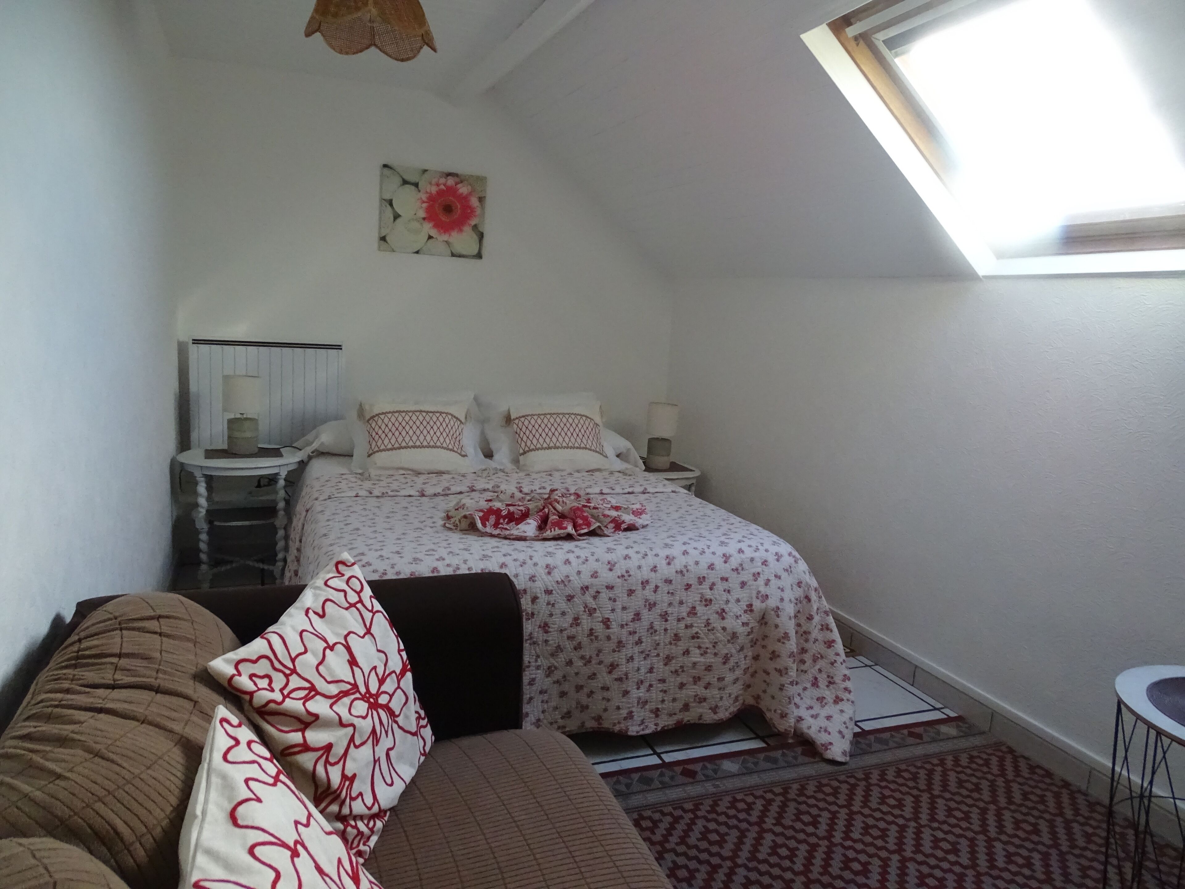 Ein Schlafzimmer mit einem Bett, zwei Nachttischen, einem Fenster und einem Deckenventilator.