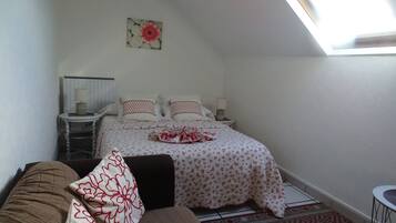 Ein Schlafzimmer mit einem Bett, zwei Nachttischen, einem Fenster und einem Deckenventilator.