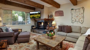 A cozy living room with a fireplace, comfortable seating, and a television. - Vantage Point 115 - 2 Bedroom Gold (Circle Vail)
