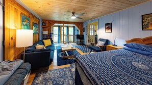 Una habitación acogedora con una cama, un sofá, una mesa de centro y un televisor.