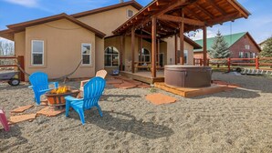 A house with a covered patio, outdoor seating, and a hot tub.
