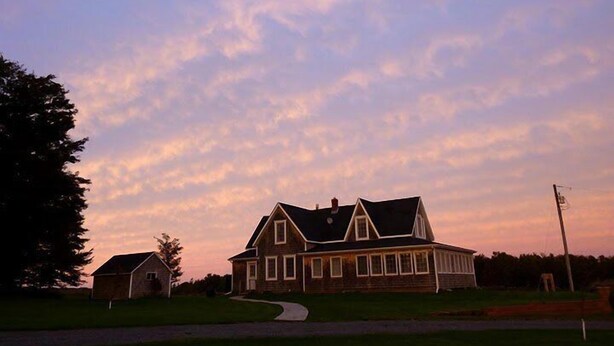 A large, two-story house with a prominent gabled roof and a front porch. - Large Century Home with Vineyard. Very private with a grand ocean view.  (Lot 63)