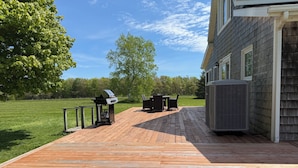 A wooden deck with outdoor furniture, a grill, and an air conditioning unit. - Large Century Home with Vineyard. Very private with a grand ocean view.  (Lot 63)