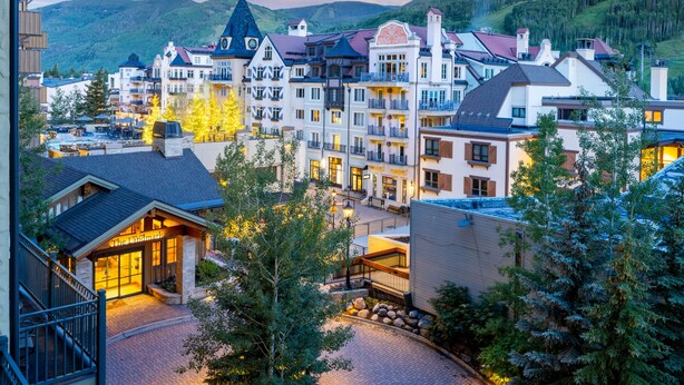 A hotel with a traditional European architectural style, featuring multiple stories, balconies, and a central courtyard.