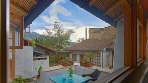 A patio with a table and chairs, surrounded by potted plants and a stone pathway. - Studio Mariposa with beautiful gardens in Historical Quito (Quito)