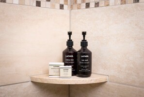 A bathroom shelf with Lather brand toiletries including a body scrub, hair wash, and face soap. - Vantage Point 102 - 2 Bedroom Gold (Vail)