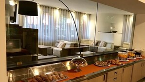 A hotel room with a breakfast bar, a sofa, and a large mirror. - Hotel Palme (Monterosso al Mare)