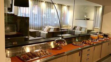 A hotel room with a breakfast bar, a sofa, and a large mirror.