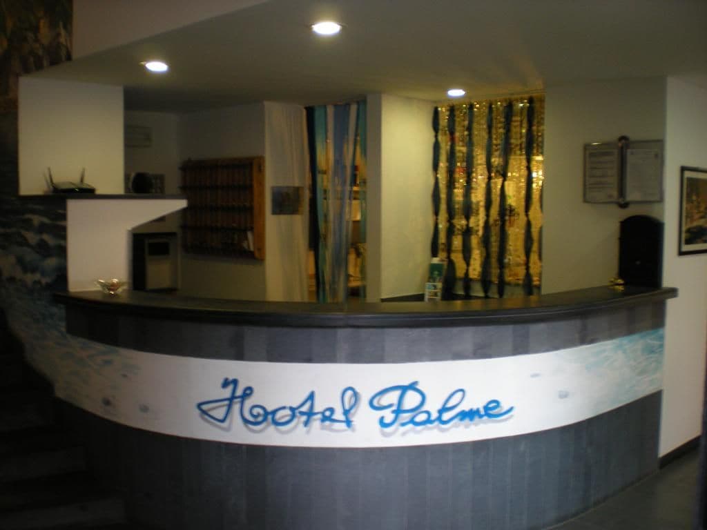 Una reception con un cartello che recita 'Hotel Palme'.