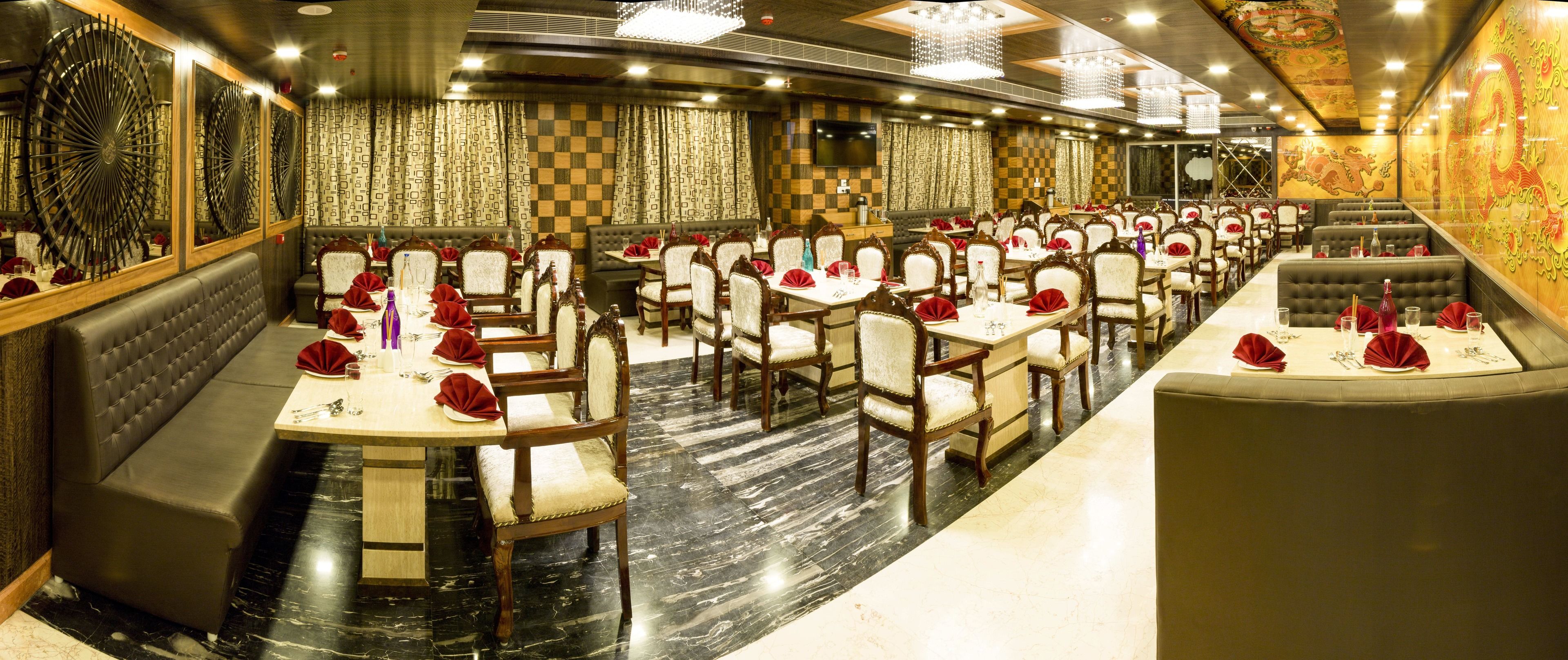 A restaurant with multiple dining tables and booths, marble flooring, and a checkered wall pattern.