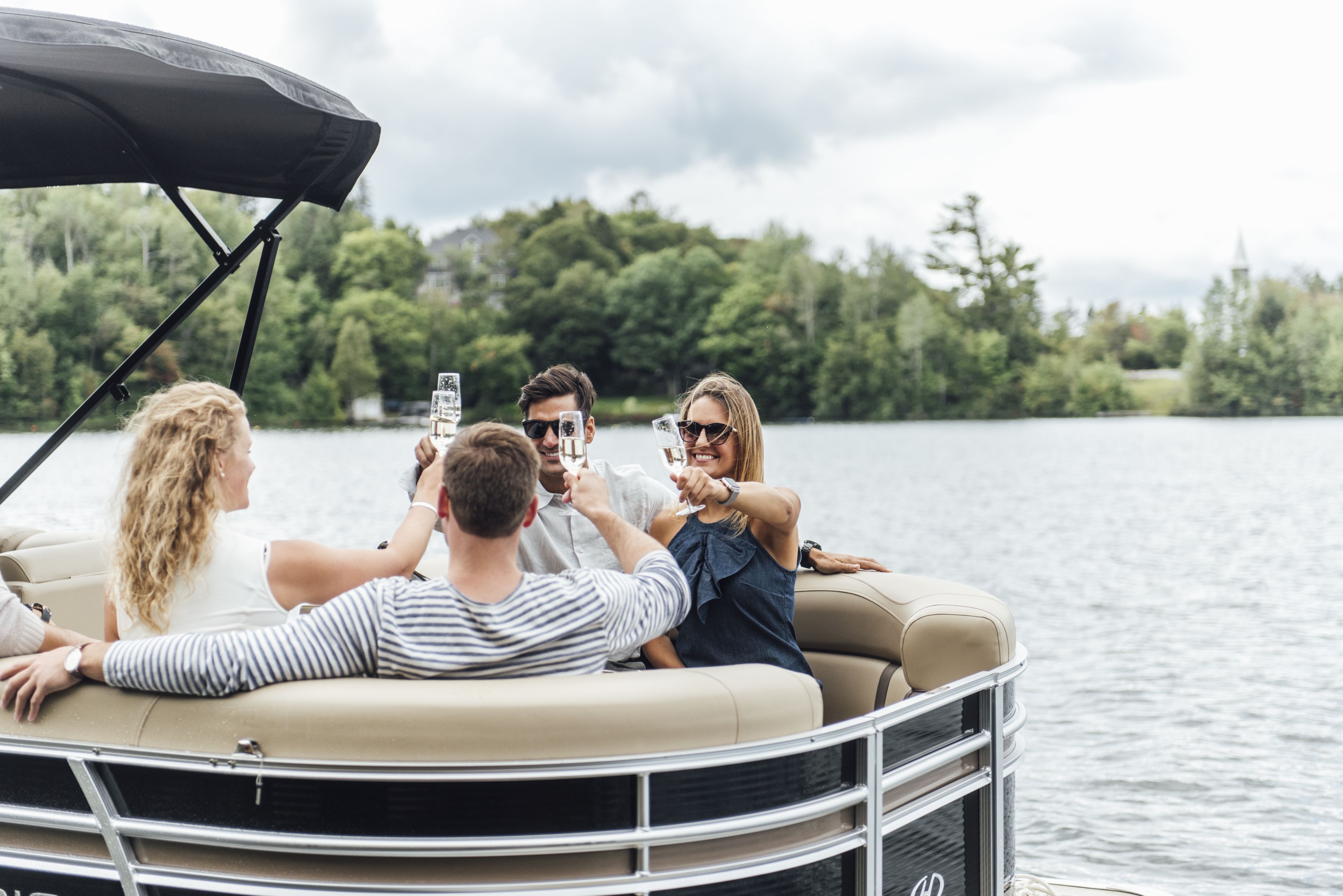 Un grupo de personas en un bote con toldo, rodeado de agua y árboles.