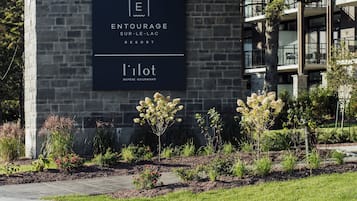 Un edificio con fachada de piedra y un letrero que dice 'ENTOURAGE SUR-LE-LAC RESORT' y 'l'ilot REFERE GOURMAND'.