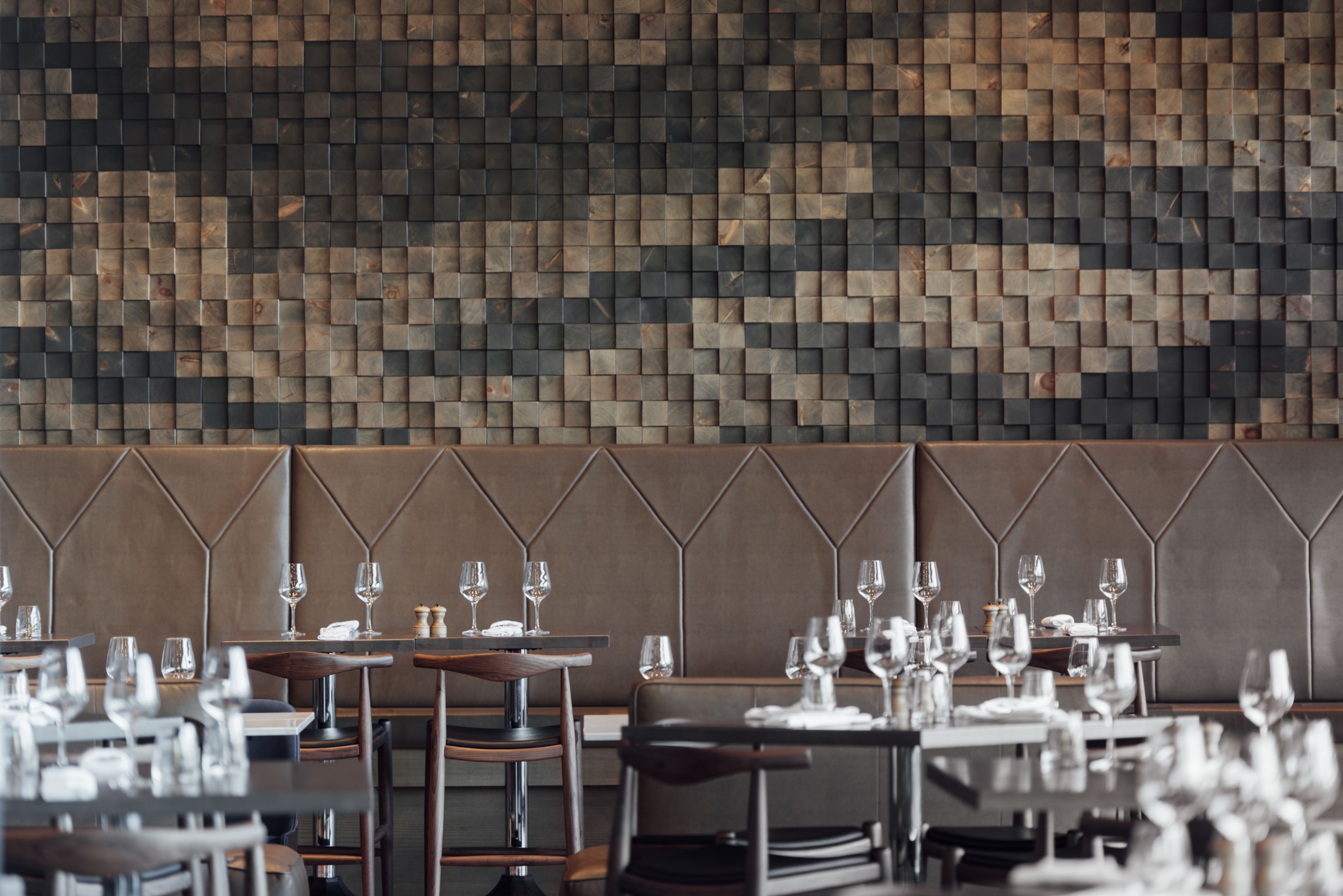 Een restaurantinterieur met een modern design, met een behang en gestoffeerde zitmogelijkheden.