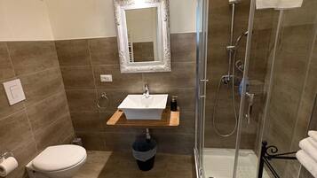 A bathroom with a toilet, sink, and shower.