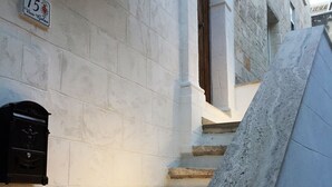 A stone staircase leading to an entrance with a mailbox and a door. - Nenetta Rooms (Monopoli)