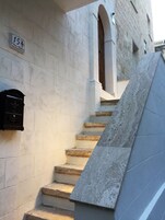 Una scala in pietra conduce a un ingresso con una cassetta delle lettere e una porta.