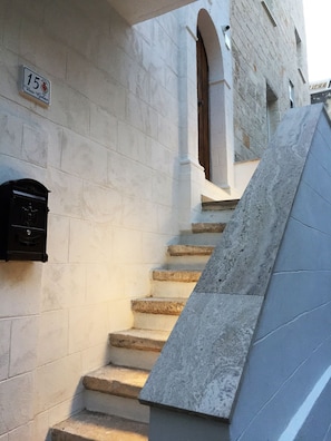 A stone staircase leading to an entrance with a mailbox and a door.