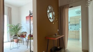 A spacious living area with a large mirror, a small table, and a potted plant. - Nenetta Rooms (Monopoli)