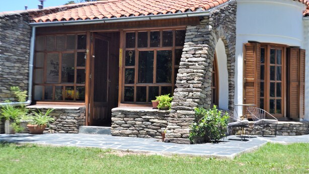 A stone building with large windows and a tiled roof.
