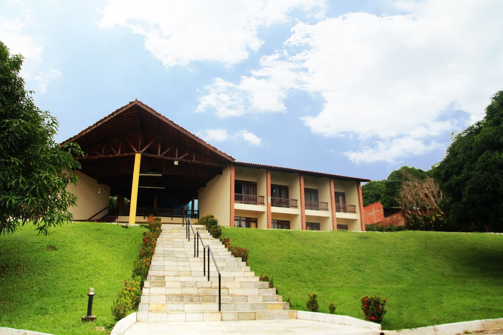 A two-story building with a covered entrance and a staircase leading up to the entrance.