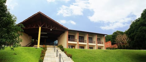 A two-story building with a covered entrance and a staircase leading up to the entrance.