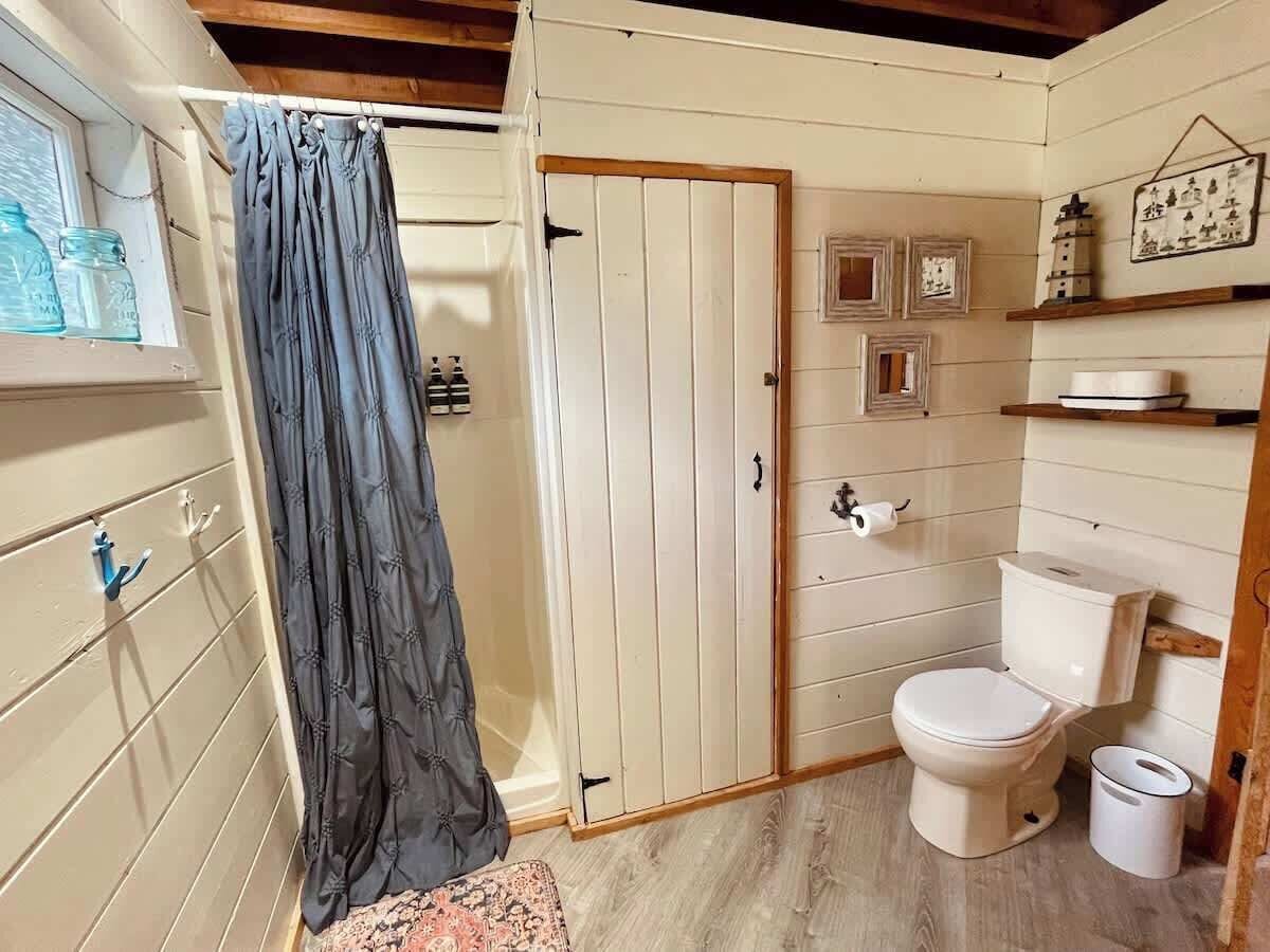 A small, compact bathroom with a toilet, a shower curtain, and a sink.