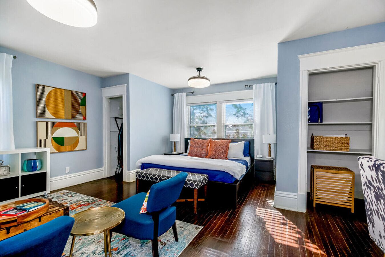 A modern bedroom with a bed, a desk, a chair, and a window.
