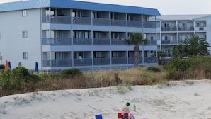 Ein Mehrstöckiges Hotel mit Balkonen in Strandnähe.