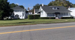 A residential street with white houses, a clear road, and a well-maintained lawn. - Casa de Flora B- Relaxed Elegance in historic St Augustine 🚭 (St Augustine)