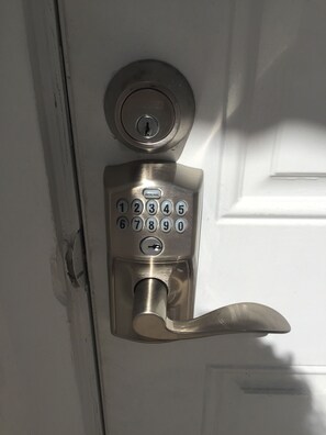 A door with a numeric keypad lock and a lever handle. - Casa de Flora B- Relaxed Elegance in historic St Augustine 🚭 (St Augustine)