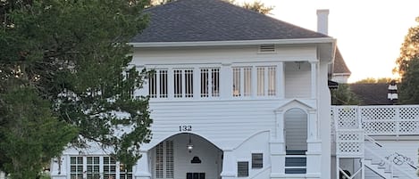 Une maison blanche à deux étages, portant le numéro 132 sur la façade.