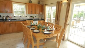 A dining area with a wooden table set for six, surrounded by six chairs.