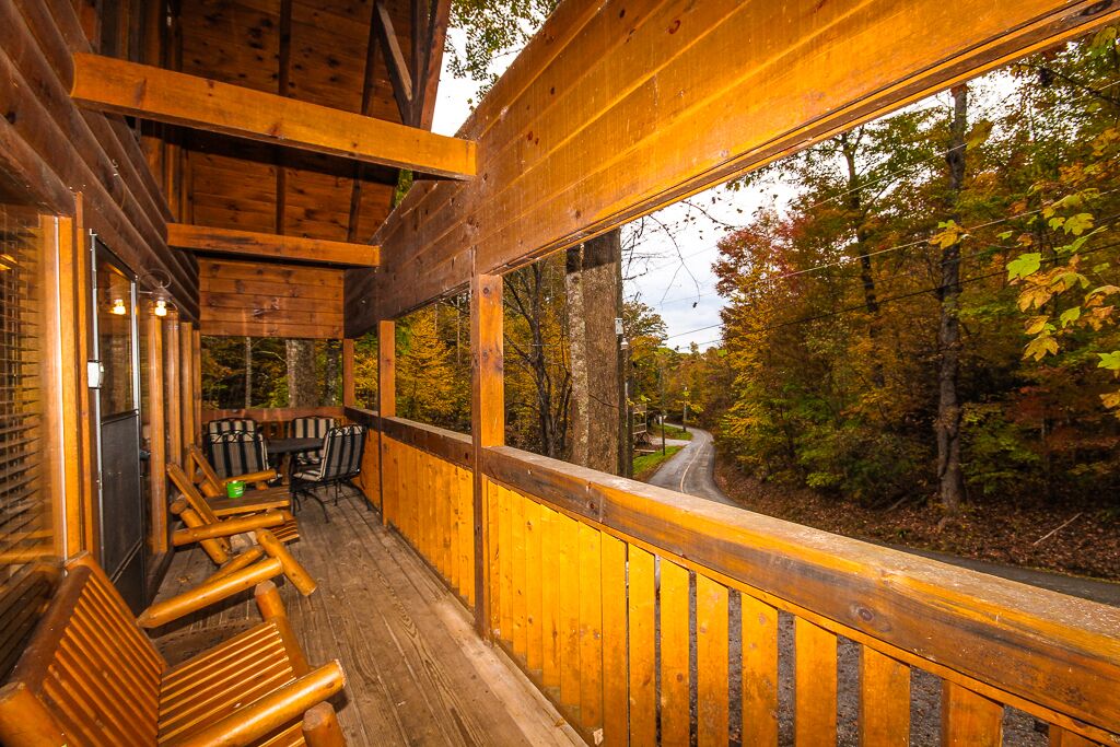 Eine Holzterrasse mit Geländer, mit Blick auf ein bewaldetes Gebiet.