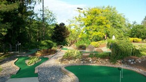 Un parcours de minigolf comportant plusieurs trous, un chemin et une végétation luxuriante tout autour.
