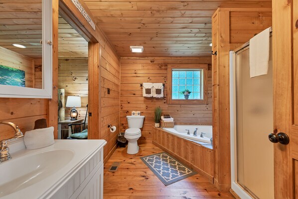 Ein Badezimmer einer Holzhütte mit Waschbecken, Toilette und Badewanne.