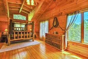 A wooden cabin interior with a bed, dresser, and large windows. - Close to hiking, waterfalls & fun! (Clyde)