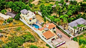 Vista aérea de una zona residencial con casas, piscina y vegetación circundante.